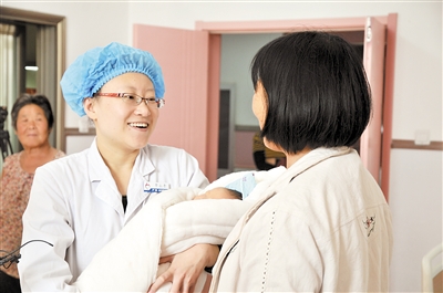 贾永青（左二）在病房与产妇交流。